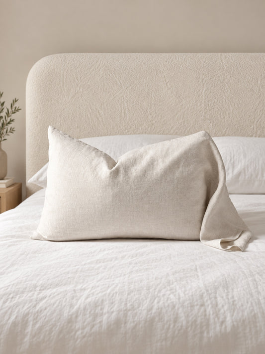Funda de cojín de lino natural Modelo Light 50 x 70 cm, color Crudo, sobre cama con respaldo Elara